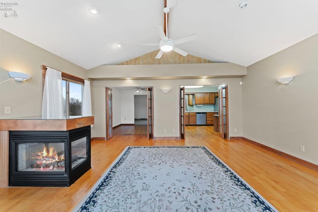 1001 Birchwood Dr, Sandusky, OH 44870 - unfurnished living room featuring lofted ceiling, a multi sided fireplace, light wood-type flooring, baseboards, and ceiling fan