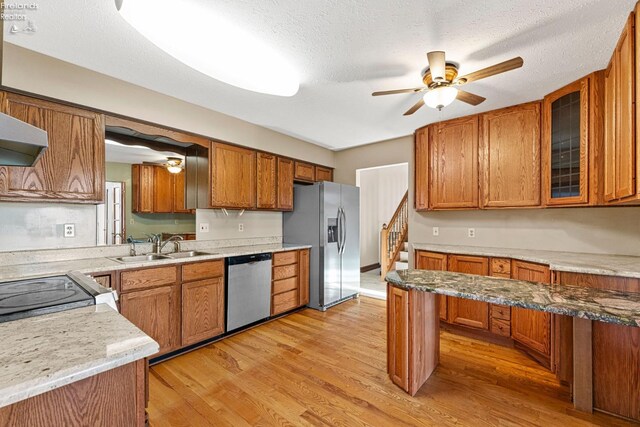 1001 Birchwood Dr, Sandusky, OH 44870 - kitchen featuring light wood finished floors, a sink, a ceiling fan, brown cabinetry, and appliances with stainless steel finishes