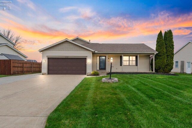 1001 Birchwood Dr, Sandusky, OH 44870 - view of front of house featuring concrete driveway, fence, a lawn, and a garage