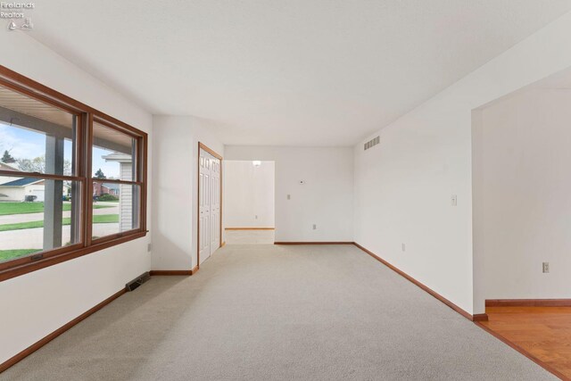 1001 Birchwood Dr, Sandusky, OH 44870 - spare room featuring visible vents, baseboards, and light carpet