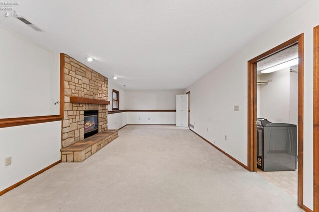 1001 Birchwood Dr, Sandusky, OH 44870 - unfurnished living room featuring washer / dryer, a stone fireplace, visible vents, and light colored carpet