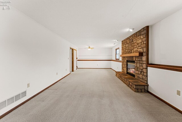1001 Birchwood Dr, Sandusky, OH 44870 - unfurnished living room with carpet flooring, baseboards, visible vents, ceiling fan, and a fireplace