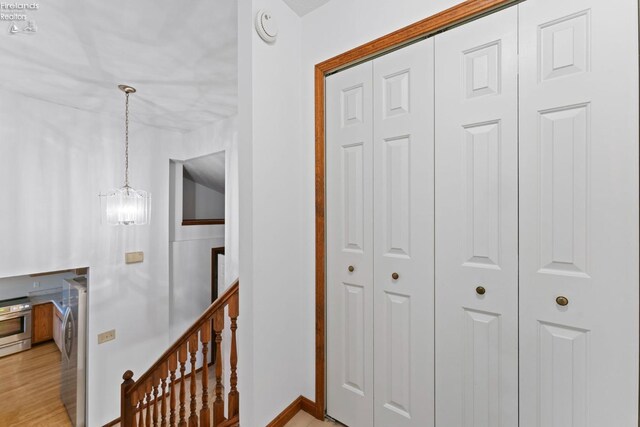 1001 Birchwood Dr, Sandusky, OH 44870 - corridor featuring baseboards, a notable chandelier, an upstairs landing, and light wood finished floors