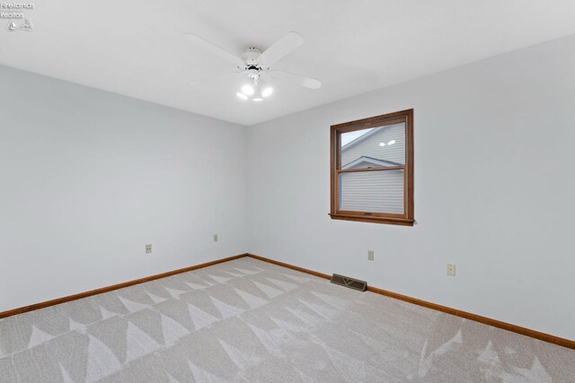 1001 Birchwood Dr, Sandusky, OH 44870 - unfurnished room with visible vents, a ceiling fan, baseboards, and light carpet