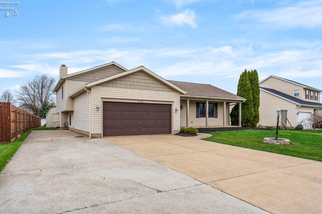 1001 Birchwood Dr, Sandusky, OH 44870 - single story home featuring a chimney, fence, a front lawn, concrete driveway, and a garage