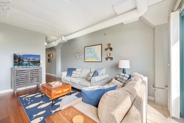 living area with baseboards, wood finished floors, and ornate columns