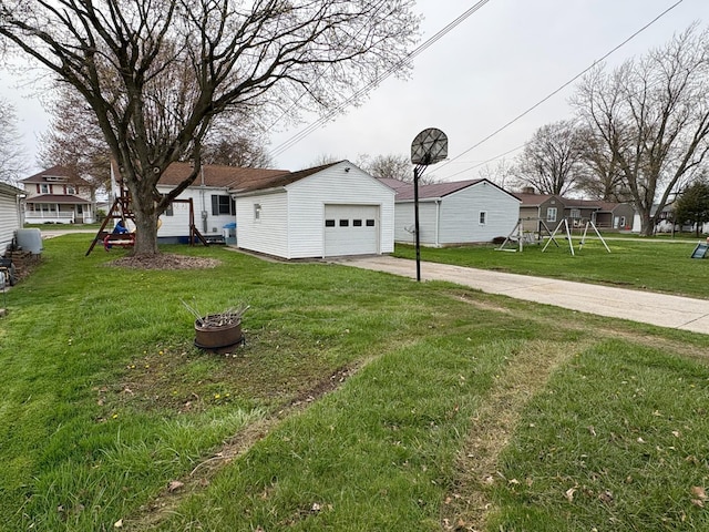 exterior space with a garage, an outbuilding, a playground, and concrete driveway