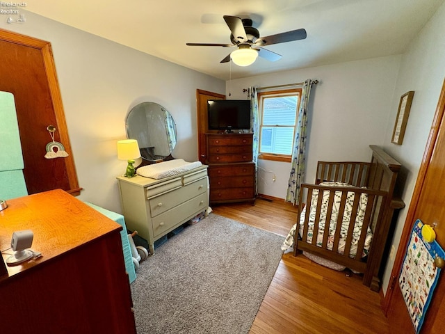 bedroom with wood finished floors, baseboards, and ceiling fan