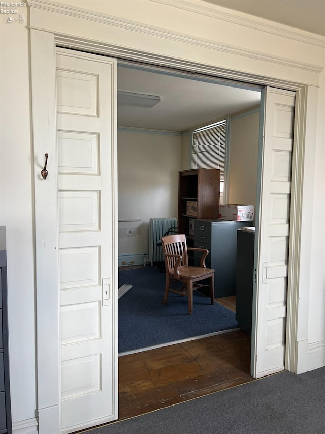 interior space featuring radiator heating unit, hardwood / wood-style flooring, and crown molding