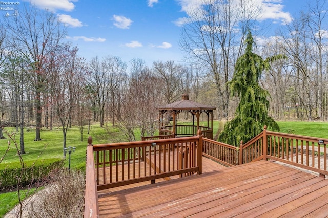 wooden deck featuring a gazebo and a lawn