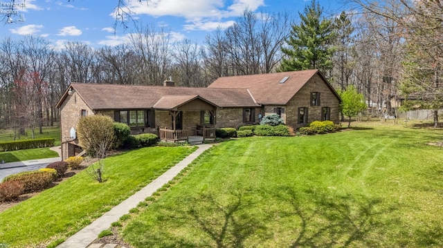 single story home featuring a front lawn, a porch, a chimney, fence, and brick siding