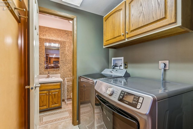 laundry room with a sink, washer and clothes dryer, and cabinet space