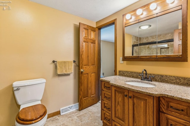 bathroom featuring baseboards, toilet, vanity, and visible vents