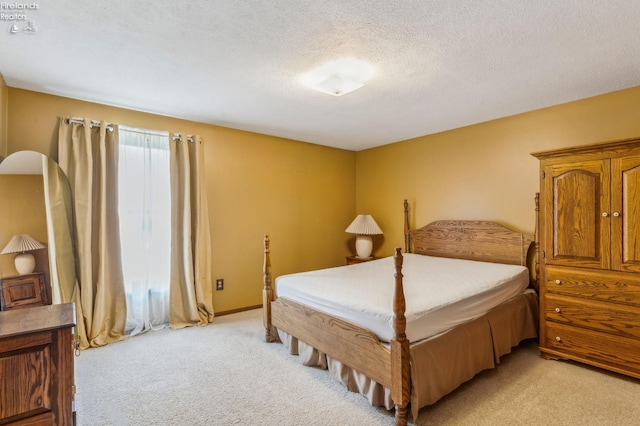 bedroom with a textured ceiling and light colored carpet