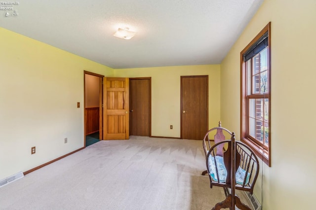 unfurnished room featuring light colored carpet, baseboards, a healthy amount of sunlight, and visible vents