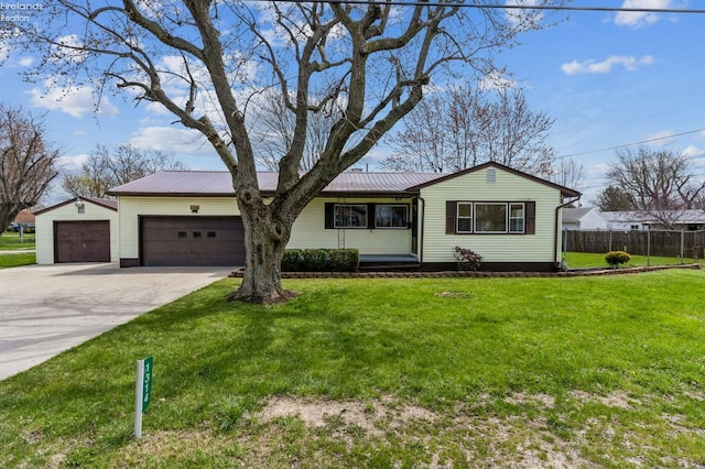 ranch-style house with fence, a garage, driveway, a front yard, and metal roof