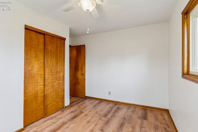 unfurnished bedroom with light wood-type flooring, baseboards, a closet, and ceiling fan