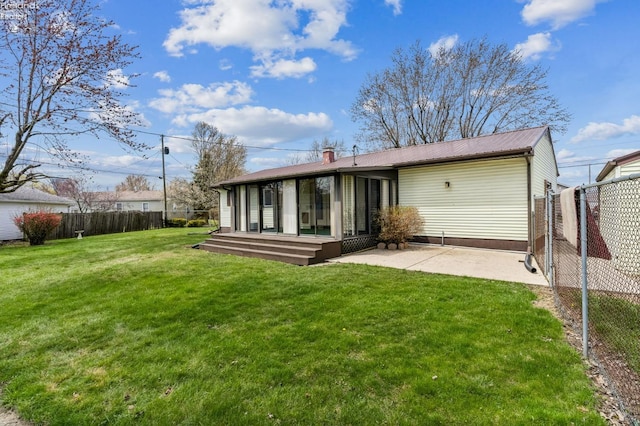 back of property featuring a lawn, a deck, fence, a patio, and metal roof
