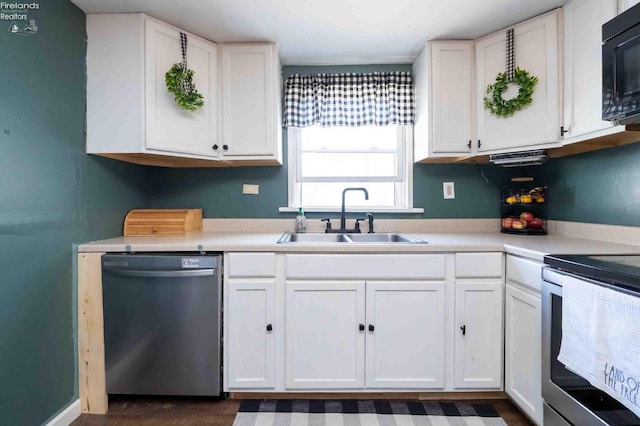 kitchen with white cabinets, appliances with stainless steel finishes, a sink, and light countertops
