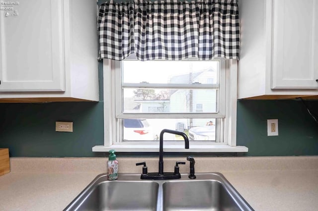 kitchen featuring white cabinetry, a sink, and light countertops