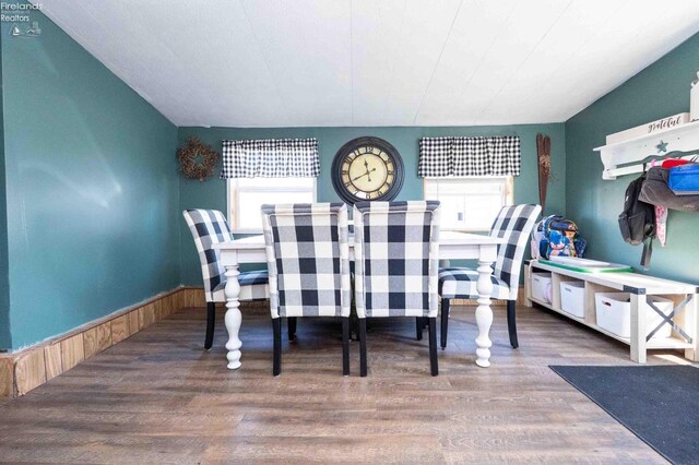 dining space with wainscoting, wood finished floors, and wooden walls