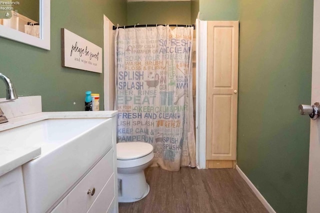full bath with a shower with curtain, wood finished floors, vanity, and toilet