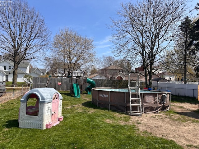 view of yard with a fenced backyard, a fenced in pool, and a residential view