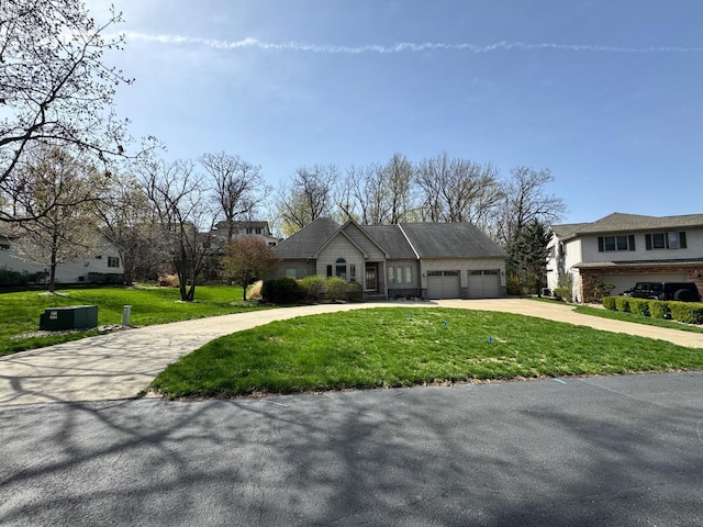 view of front of property featuring curved driveway, a garage, and a front yard