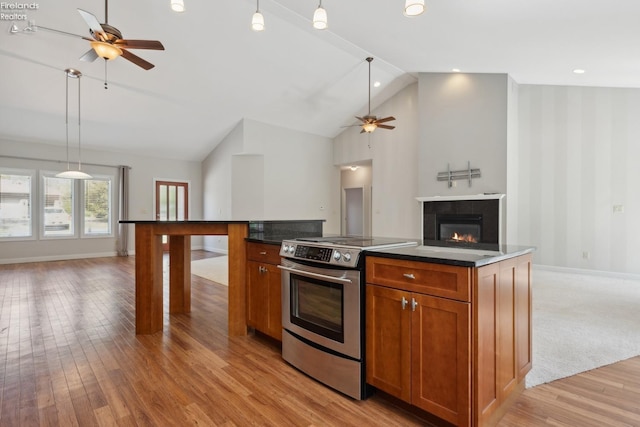 kitchen with dark countertops, ceiling fan, electric range, and open floor plan
