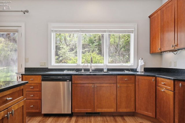 kitchen with a sink, light wood-style floors, brown cabinets, and dishwasher