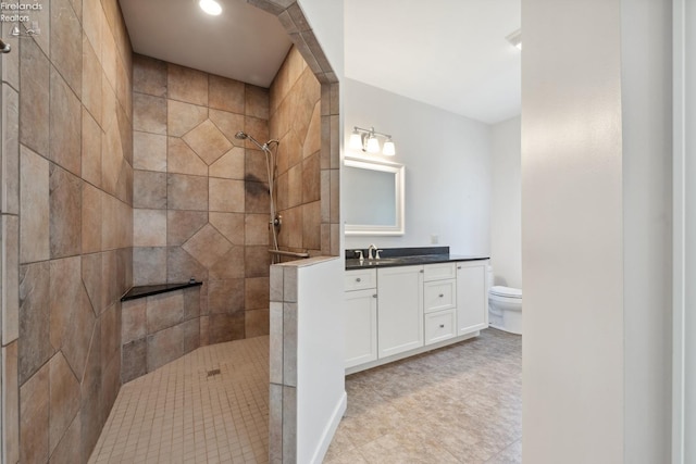 bathroom featuring recessed lighting, a walk in shower, vanity, and toilet