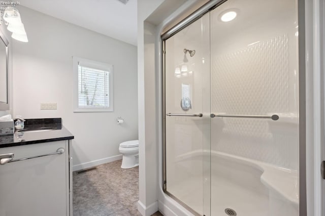 full bath with vanity, a shower stall, and toilet