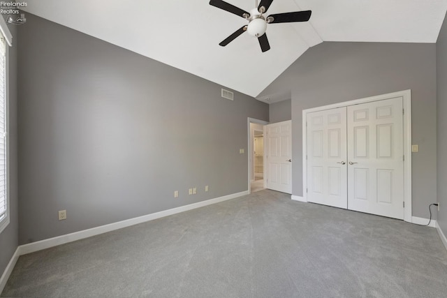 unfurnished bedroom with visible vents, baseboards, high vaulted ceiling, carpet floors, and a closet