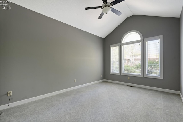 empty room featuring a ceiling fan, baseboards, light carpet, and lofted ceiling