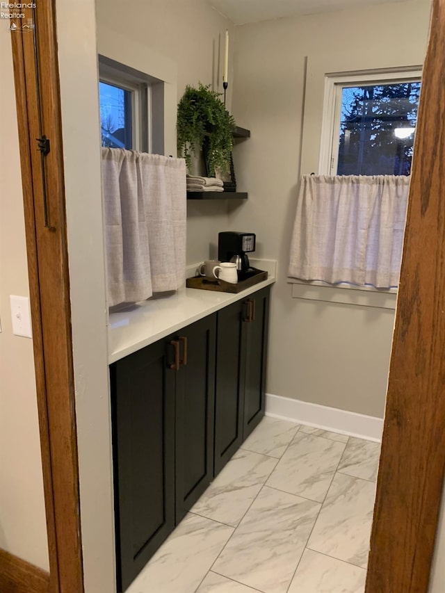 bathroom with marble finish floor and baseboards