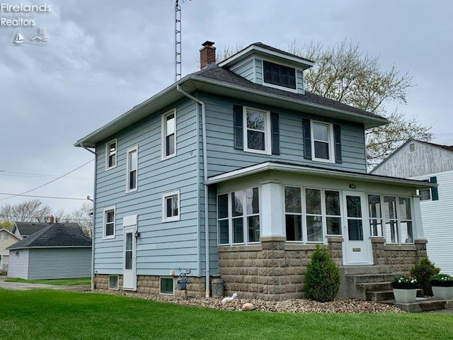 rear view of house featuring a chimney, entry steps, and a lawn