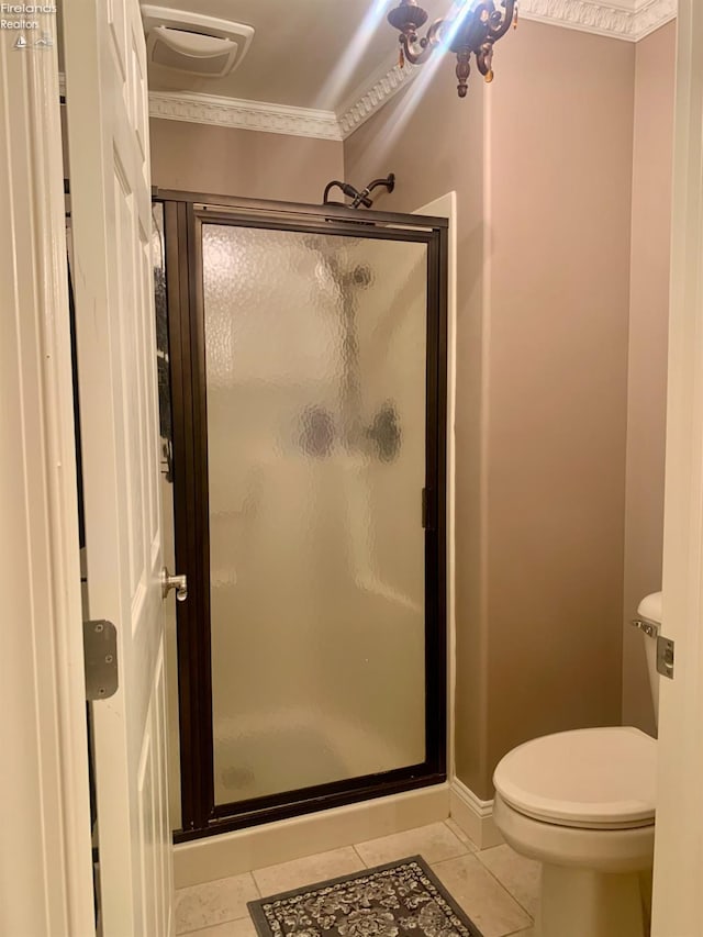 bathroom featuring a shower stall, toilet, ornamental molding, and tile patterned flooring