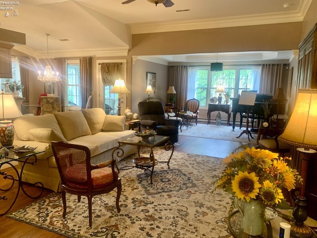 living room featuring ceiling fan with notable chandelier, wood finished floors, and a healthy amount of sunlight