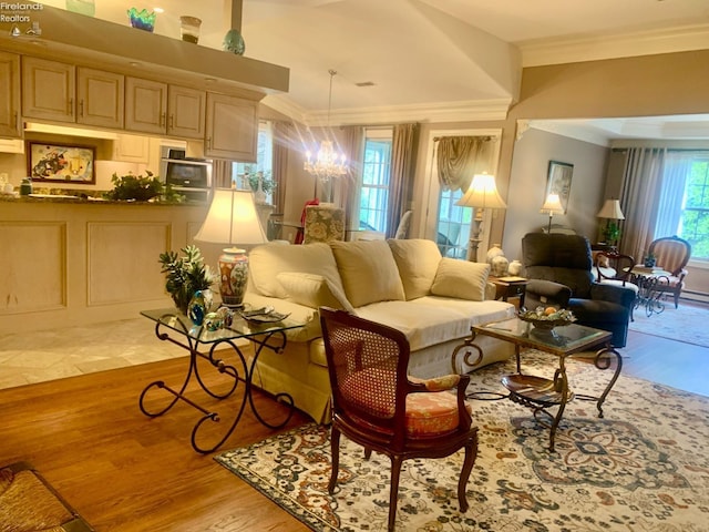 living area featuring wood finished floors, an inviting chandelier, and crown molding
