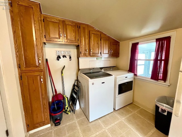 clothes washing area featuring washer and clothes dryer and cabinet space