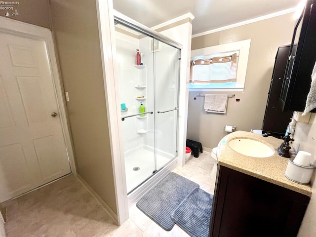 full bath with vanity, baseboards, crown molding, and a shower stall