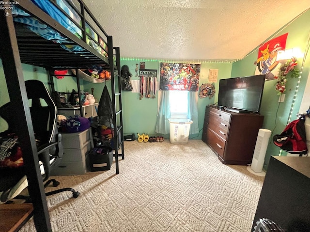bedroom featuring light carpet and a textured ceiling