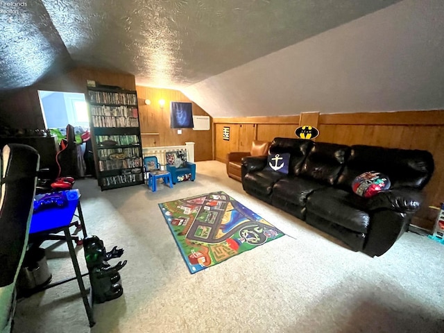 playroom with a textured ceiling, wood walls, vaulted ceiling, and carpet