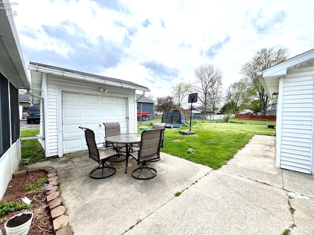 view of patio featuring a playground, fence, an outbuilding, and outdoor dining space