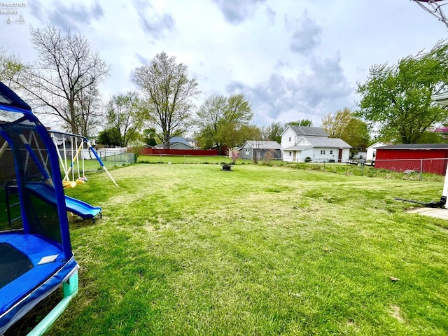 view of yard with a playground, a fenced backyard, and a trampoline