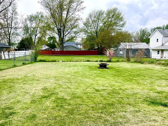 view of yard with fence and an outdoor fire pit