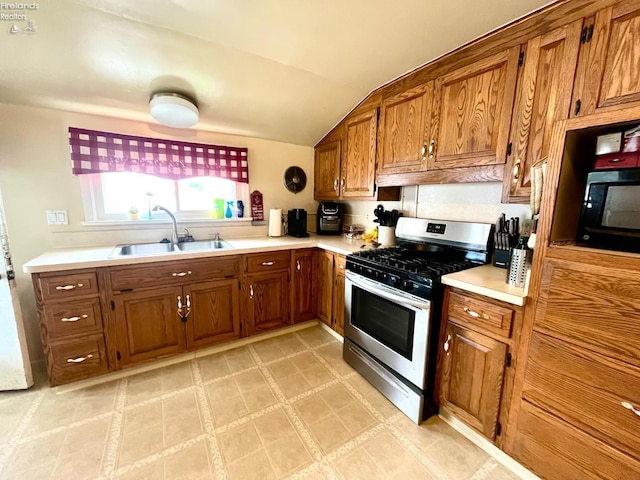 kitchen featuring a sink, stainless steel gas range, and brown cabinets