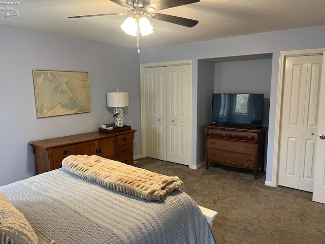 bedroom with multiple closets, baseboards, ceiling fan, and dark colored carpet