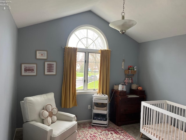 bedroom featuring a nursery area, vaulted ceiling, multiple windows, and carpet floors