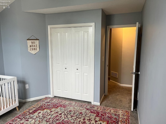 bedroom featuring baseboards, carpet flooring, visible vents, and a closet